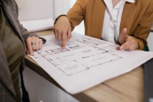 imagen de dos personas viendo planos de una vivienda para cambiar de local a vivienda